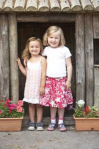 Two Young Girls Playing in Wooden House