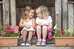 Two Young Girls Playing in Wooden House
