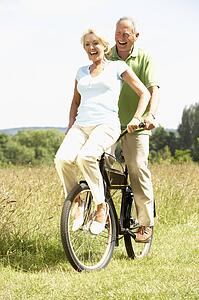 Mature couple riding bike in countryside