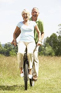 Mature couple riding bike in countryside