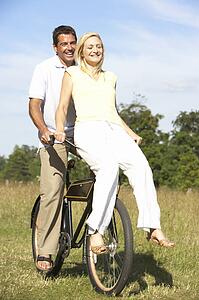 Young couple riding bike in countryside