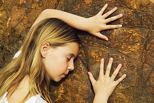 Child touching a rock