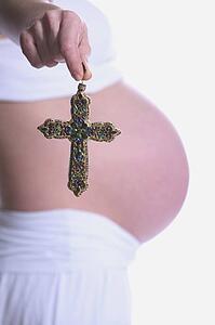 Pregnant woman holding a cross