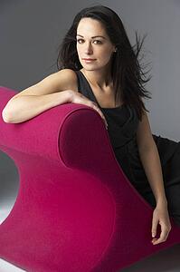 Studio Portrait Of Woman Relaxing On Pink Chaise Longue