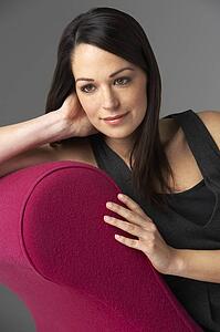 Studio Portrait Of Woman Relaxing On Pink Chaise Longue