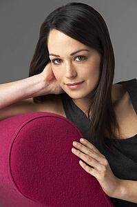 Studio Portrait Of Woman Relaxing On Pink Chaise Longue