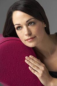 Studio Portrait Of Woman Relaxing On Pink Chaise Longue