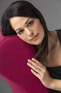 Studio Portrait Of Woman Relaxing On Pink Chaise Longue