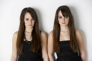Studio Portrait Of Fashionably Dressed Twin Teenage Girls