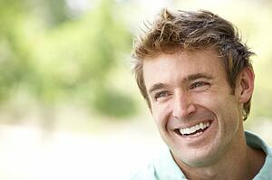 Portrait Of Young Man Sitting In Park