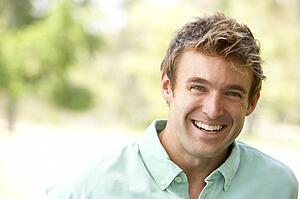 Portrait Of Young Man Sitting In Park
