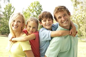 Mother And Father Giving Children Piggy Back