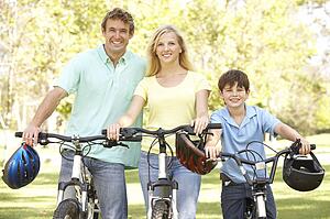 Parents And Son On Cycle Ride In Park