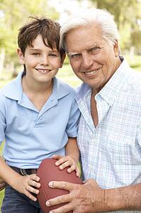 Grandfather And Grandson Playing American Football Together