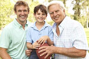Grandfather With Father And Son Playing American Football Together