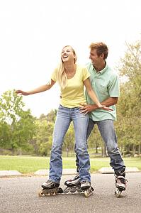 Couple Wearing In Line Skates In Park