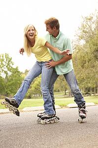 Couple Wearing In Line Skates In Park