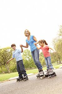 Grandmother And Grandchildren Skating In Park