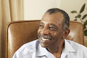 Senior Man Relaxing In Chair At Home
