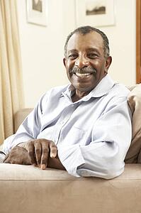 Senior Man Relaxing In Chair At Home