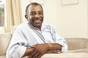 Senior Man Relaxing In Chair At Home