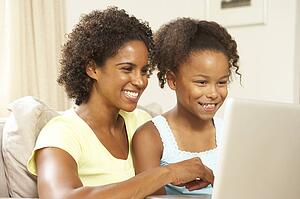 Mother And Daughter Using Laptop At Home