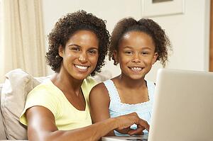 Mother And Daughter Using Laptop At Home