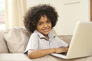 Young Boy Using Laptop At Home