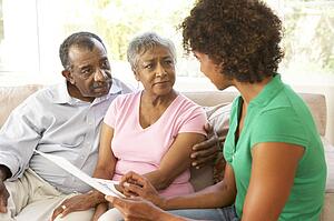 Senior Couple Talking To Financial Advisor At Home