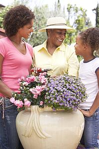 Senior Woman With Adult Daughter Gardening Together