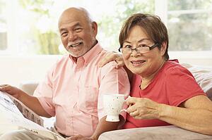Senior Couple Reading Newspaper At Home
