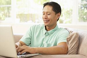 Young Man Using Laptop At Home