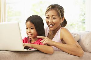 Mother And Daughter Using Laptop At Home