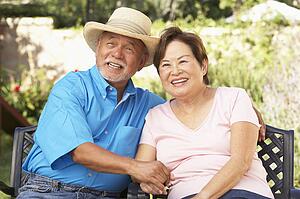 Senior Couple Relaxing In Garden Together