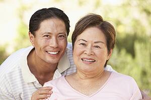 Senior Woman With Adult Son In Garden
