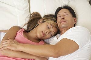 Young Couple Asleep In Bed