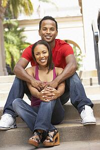 Young Couple Sitting On Steps Of Building