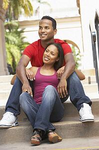Young Couple Sitting On Steps Of Building
