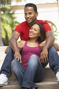 Young Couple Sitting On Steps Of Building