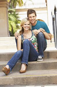 Young Couple Sitting On Steps Of Building