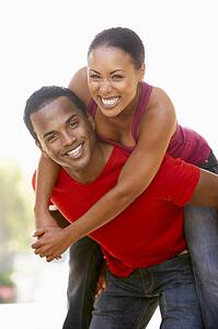 Young Man Giving Woman Piggyback Outdoors