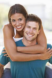 Young Man Giving Woman Piggyback Outdoors