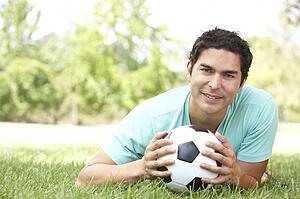 Portrait Of Young Man In Park With Football