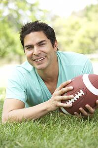 Portrait Of Young Man In Park With American Football