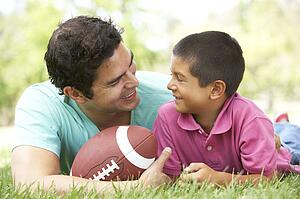Father And Son In Park With American Football