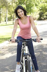 Young Woman Riding Bike In Park