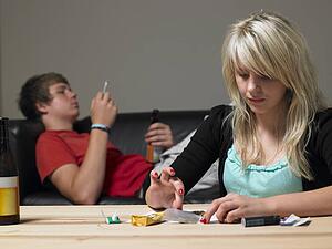 Teenage Couple Taking Drugs At Home