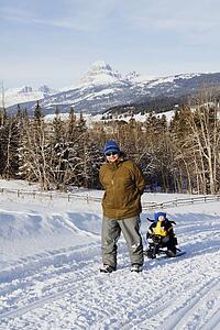 Father pulling son on sled in the winter