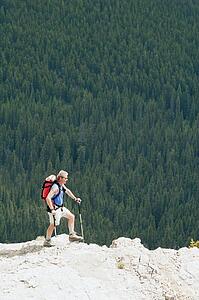 Man hiking on a ridge overlooking a forest