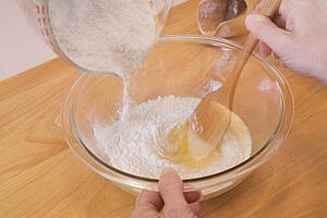 person mixing ingredients into a bowl